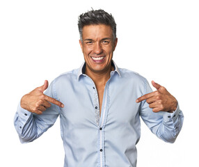 Middle-aged Latino man surprised pointing with finger, smiling broadly.