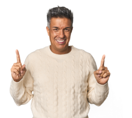 Middle-aged Latino man indicates with both fore fingers up showing a blank space.