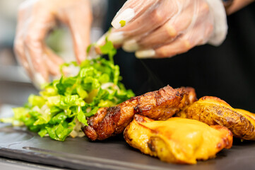 woman chef hand cooking grilled pork neck with baked potatoes and salad