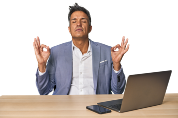 Elegant businessman at desk with laptop relaxes after hard working day, she is performing yoga.