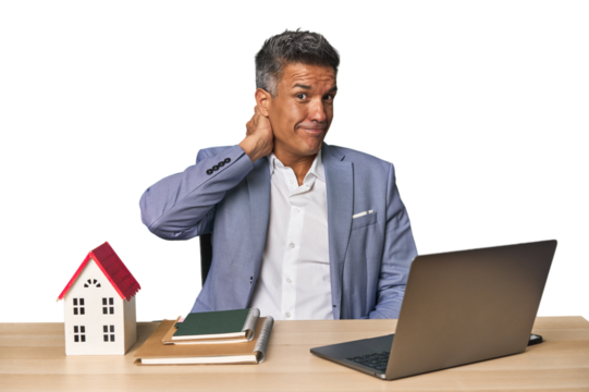 Middle-aged Hispanic businessman with real estate theme touching back of head, thinking and making a choice.