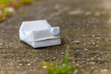an old milk carton on a footpath