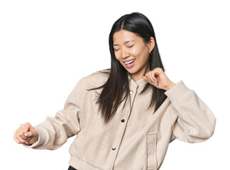 Young Chinese woman in studio setting dancing and having fun.