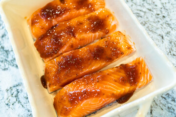Baking fresh salmon with teriyaki in ceramic dish