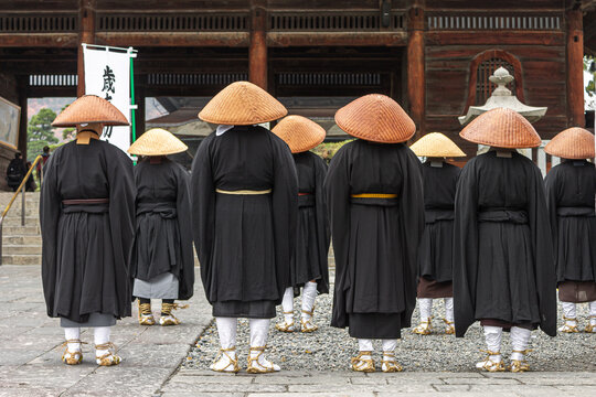 Nagano, Japan. Japanese Zen Buddhist monks of the Soto school with Kasa hats looking at the Sanmon Gate in Zenko-ji, a buddhist temple