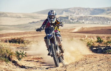 Person, professional motorcyclist and dirt track for race, extreme sports or outdoor competition. Expert rider on motorbike or scrambler for sand course, challenge or off road rally in nature dunes