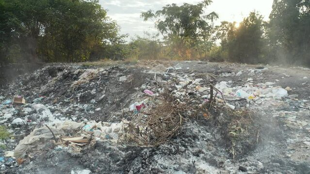 Garbage, fire burning and smoke in landfill. Also called trash, waste, rubbish. Destruction with combustion, heat, flame. Effect to environmental i.e. air pollution, toxic, disaster and global warming