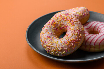Delicious sweet bright donuts with cream on a plain background