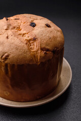 Delicious sweet holiday panettone cake with zest and raisins on a ceramic plate