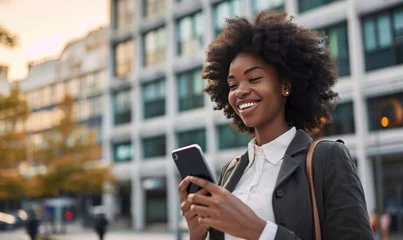 Poster Happy busy young African American business woman using mobile phone outdoors. Smiling female professional holding smartphone walking at city street looking at cell working outside, Generative AI © Media Masterpieces