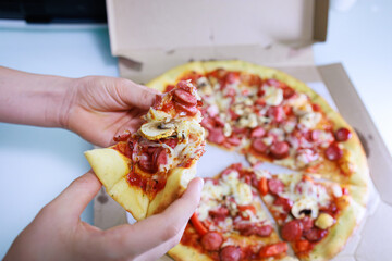The children's hands hold a slice of pizza in front of them Sausage and cheese pizza.