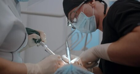 The dental surgeon does the surgery with assistant in stomatological clinic