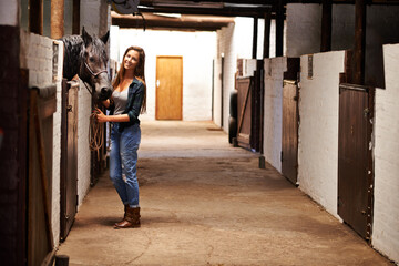 Woman, portrait and happy with horse in stable for bonding, sports training and recreation in...