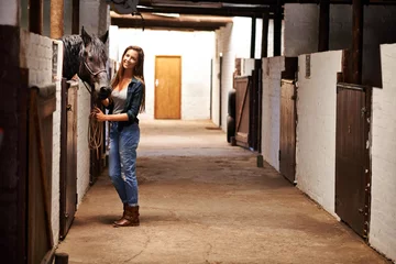 Fotobehang Woman, portrait and happy with horse in stable for bonding, sports training and recreation in Texas. Stallion, person and animal or face in barn with smile for healthy livestock, hobby and pet care © Y.A./peopleimages.com