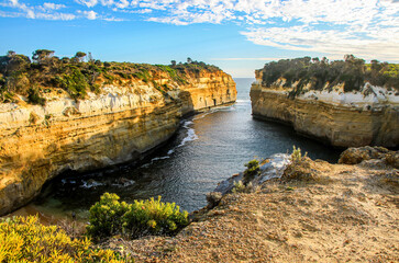 Waters of the Tasman Sea entering Loch Ard Gorge surrounded by sandstone cliffs at the Twelve...