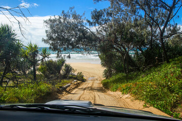 First person view of a driver travelling onboard a 4x4 pickup on a sand track in the rainforest of Fraser Island, Queensland, Australia