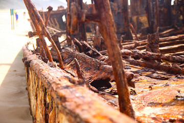 Rusty crumbling piece of the SS Maheno shipwreck half buried in the sand of the 75 mile beach on...