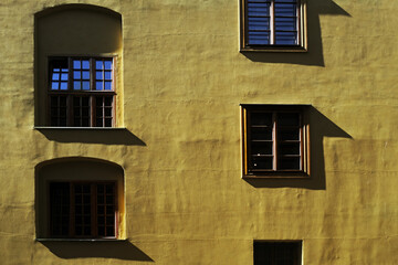 Exterior background, beautiful yellow wall building with windows and shadows in the Old town (Stare Miasto) of Warsaw, capital of Poland