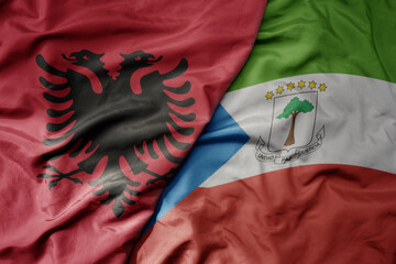 big waving national colorful flag of equatorial guinea and national flag of albania .
