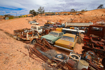 Junkyard of rusty abandoned vintage cars in the desert of the Australian outback of the red center...