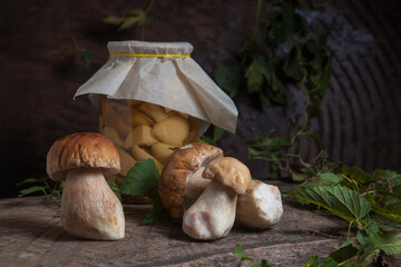 Porcini mushroom commonly known as Boletus Edulis and glass jar with canned mushrooms on vintage...