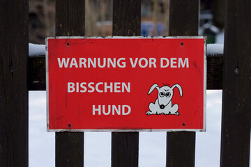 A83CH7 red danger sign beware of the dog fixed on a garden door fence
