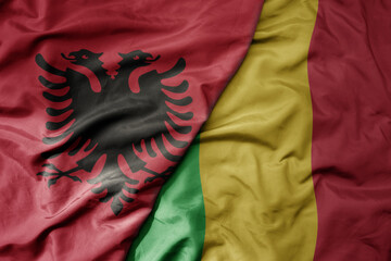 big waving national colorful flag of mali and national flag of albania .