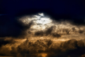 Obraz premium Evening sunlight breaks through dark clouds, gloomy light in the sky
