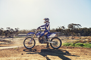 Man, motorbike and outdoor on trail for extreme sport in profile on dirt, path or countryside in summer. Person, motorcycle and gravel on road with vehicle, machine or fast transport in competition
