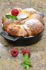 Freshly baked buns with raspberries and powdered sugar.