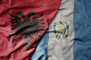 big waving national colorful flag of guatemala and national flag of albania .