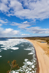 Baikal Lake in Spring time. Top view of sandy beach of Sarayskiy Bay during ice drift on sunny May day. Beautiful spring landscape of Olkhon Island. Natural background. Travel in low season