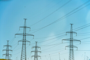 High voltage towers with sky background. Power line support with wires for electricity transmission. High voltage grid tower with wire cable at distribution station. Energy industry, energy saving