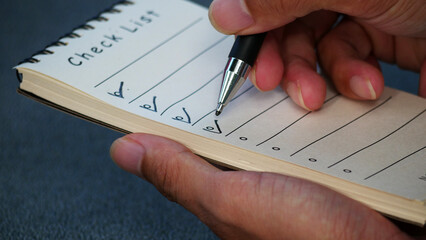 Close-up of businessman preparing checklist at office desk