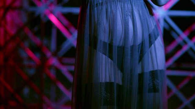 beautiful woman in erotic lingerie and black stockings dancing in dark room, closeup of belly