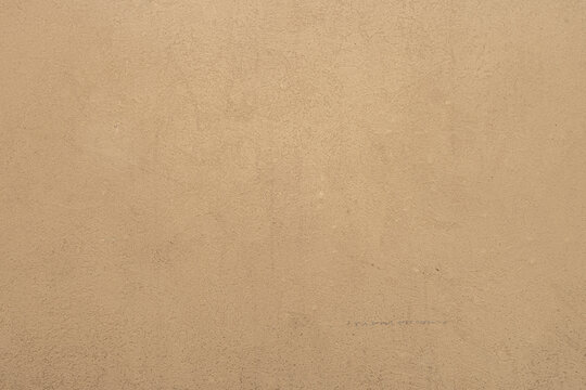 abstract background of beige embossed plastered wall painted light ocher close up