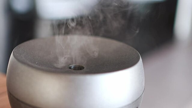 Close up view of grey aroma oil diffuser on light table at home, air freshener