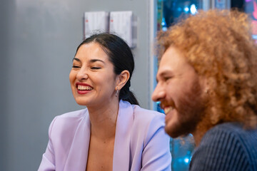 Fototapeta premium Coworkers share a joyful moment with laughter in a bright, friendly office kitchen environment. 