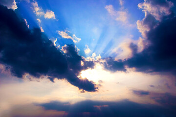 sun behind clouds and sun beams