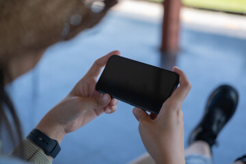 Young woman holding mobile in a train station. Commuting to work. Public transport concept