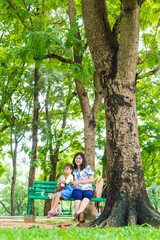 Adorable little asian daughter relax in city publice green park with mom - 742699243