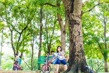 Adorable little asian daughter relax in city publice green park with mom - 742700833