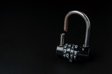Broken padlock with a sawn shackle on a black background