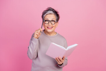 Photo of excited cheerful senior woman wear trendy clothes hold pencil notepad checklist isolated...