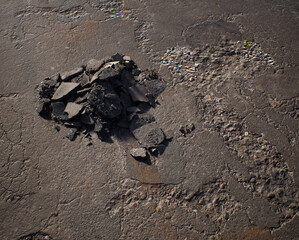 Pile of rubble on an old cracked tarmac surface. - 742708241