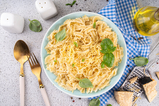 Mafaldine pasta with white sauce, italian bechamel, creamy cheese sauce pasta on white concrete background, with ingredients and spices, copy space