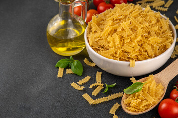 Raw uncooked Mafaldine pasta with ingredients for cooking. Short italian Mafaldine pasta with olive...