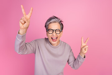 Photo of positive crazy funny senior woman wearing stylish clothes showing v-sign cool party...