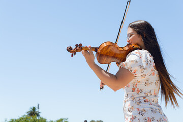 young busker woman violinist doing performance outdoors