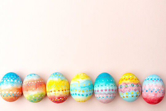 Easter background. Handmade painted eggs lie on a pink background.